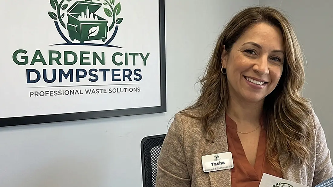 Tasha at the Garden City Dumpsters office with a service flyer